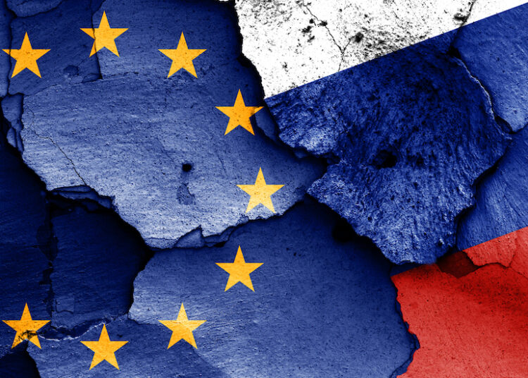 flags of European union and Russia painted on cracked wall